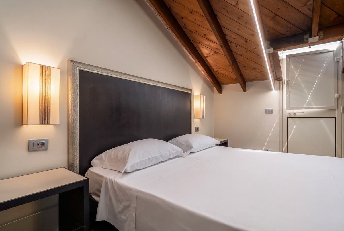 Ai Cannoni — il letto e la porta-finestra che dà sulla luce del mattino