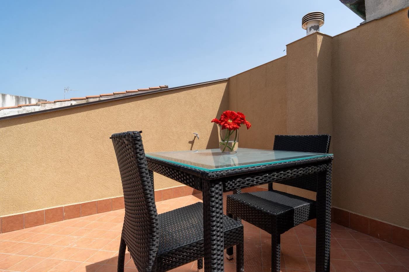 Ai Cannoni — la terrazza con il tavolo e le gerbere rosse