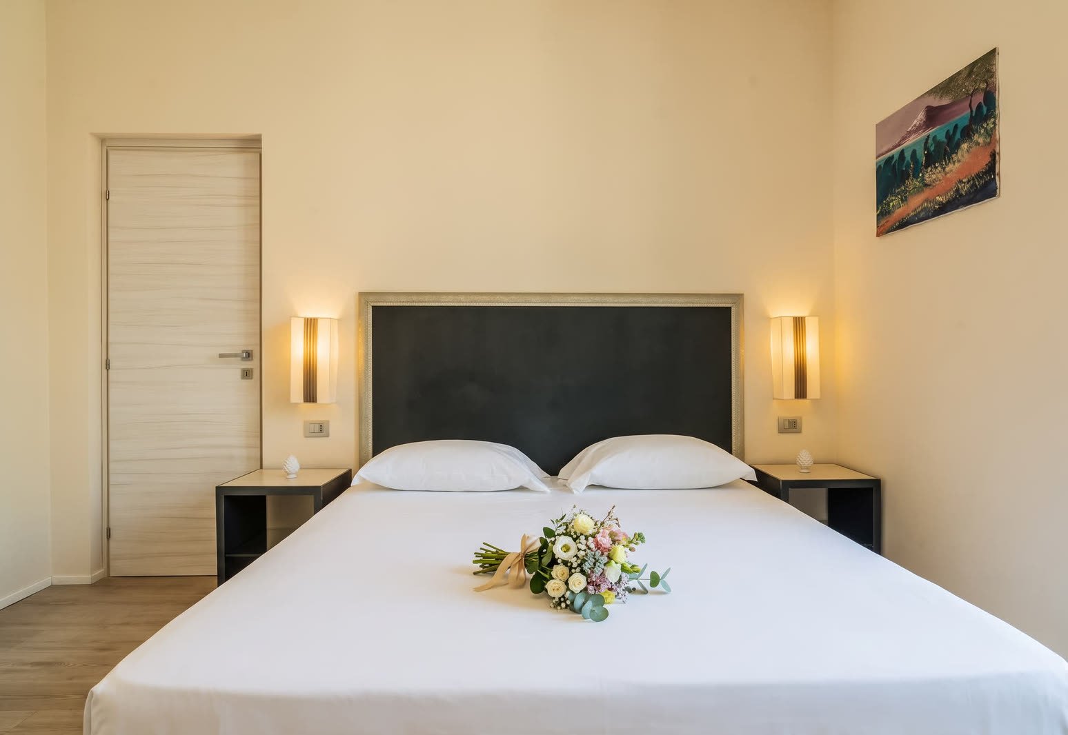 Al Ciclope — letto matrimoniale con quadro della costa e applique ai lati